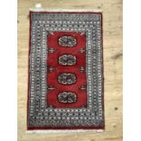 A modern Bokhara rug having a red ground with four medallions within three pale grey borders and end
