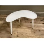 A late 50's early 60's white painted kidney shaped occasional table on three tapered legs