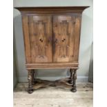 A 19th century continental oak two door cabinet on stand having a projecting cornice above two