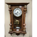 A 19th century polished beech wall clock having a two part enamel dial with Roman numerals,