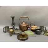 A copper kettle, brass dinner gong and beater, trivet, brass ornaments, turned wooden bowl and