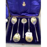 A cased set of silver plated dessert servers including four spoons and a sugar sifting spoon with