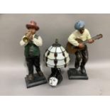 Two figures of musicians playing trumpet and guitar together with a Tiffany style table lamp