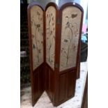 A pair of teak three fold screens, inset with crewel work embroidered panels of trailing flowers