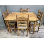 A pine extending dining table and four rush seated wavy ladderback chairs