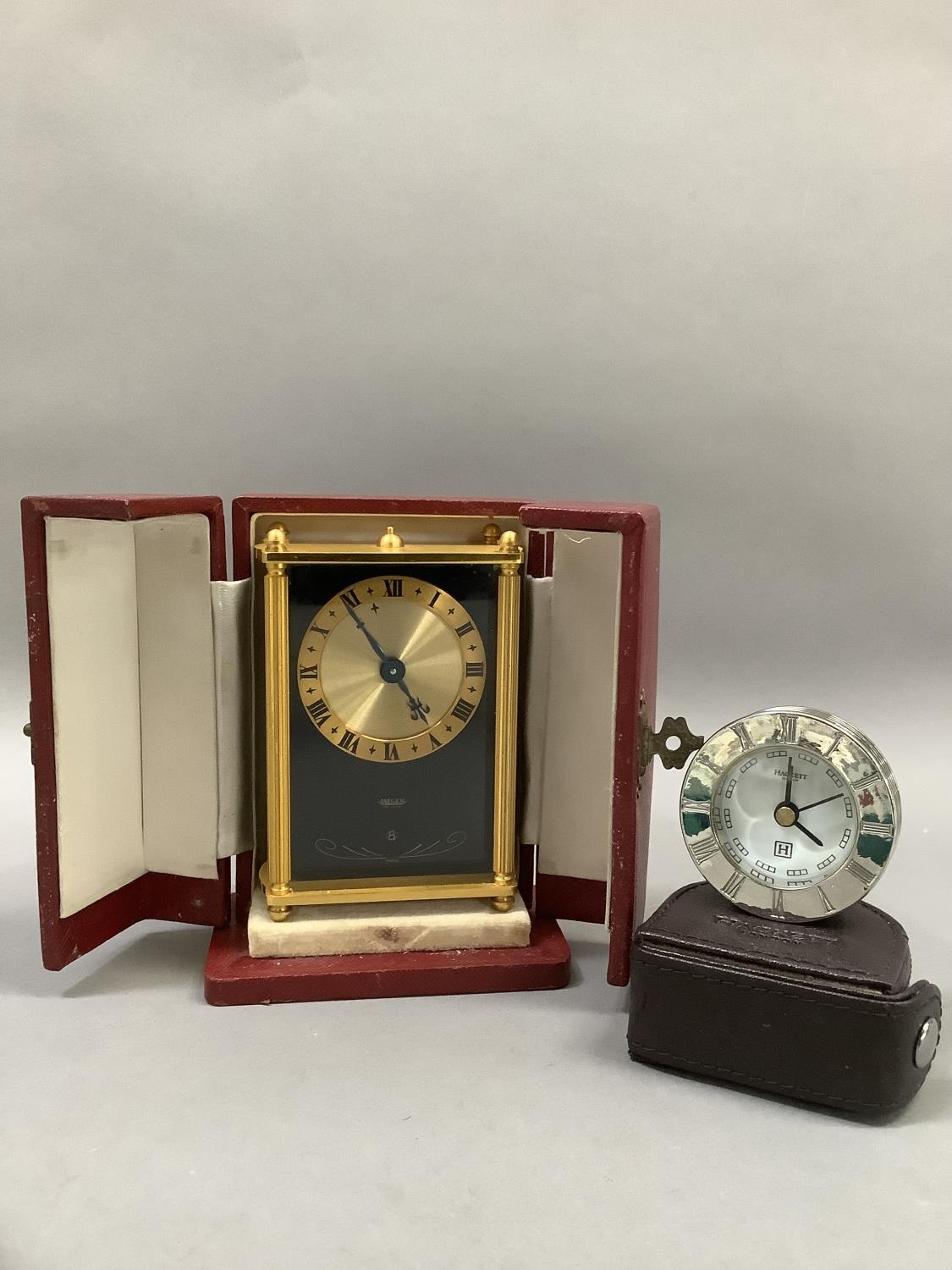 A Jaeger boudoir clock having a black face with gilt metal chaptering and black Roman numerals,