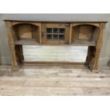 An Art Nouveau oak mirror back having a single door cupboard with six pane bubble glass inset,