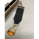 A George V pocket watch fob ribbon with swivel fastener, amber paste and rolled gold fittings