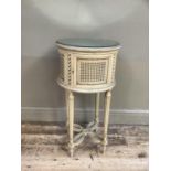 A French style cream bergere caned drum bedside cabinet with mirrored top on fluted legs joined by a