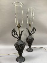 A pair of spelter type ewers cast with cherubs and face masks as lamps, with shades