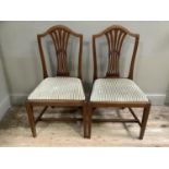 A pair of Hepplewhite style mahogany dining chairs with pierced splats, drop in upholstered seats