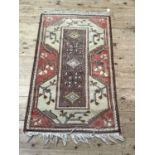 A Turkish village rug hand knotted in classic colours of mushroom, ivory, salmon and brown, 140cm