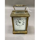 A brass carriage clock, white enamel dial with black Roman numerals signed Hewitt & Son, Paris,
