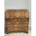 A good reproduction figured walnut bureau having a fall front, the interior fitted above two short