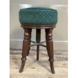 A Victorian mahogany revolving piano stool on reeded and turned legs