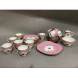 A Court china tea service of rose pink ground centred with a basket of flowers, a gilt rim line