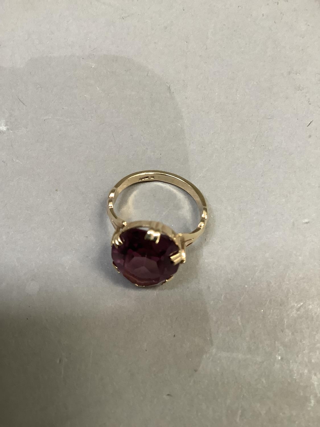 A dress ring c.1950 claw set in 9ct gold with an oval faceted purple paste, approximate weight 4g