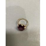 A dress ring c.1950 claw set in 9ct gold with an oval faceted purple paste, approximate weight 4g