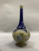 A Doulton Lambeth stoneware bottle shaped vase of blue and olive green glaze moulded with panels