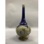 A Doulton Lambeth stoneware bottle shaped vase of blue and olive green glaze moulded with panels
