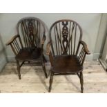A pair of dark polished beech wheel back armchairs on turned legs with H-stretchers