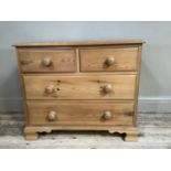 A modern pine chest of two short and two long drawers with turned handles, on shaped ogee bracket