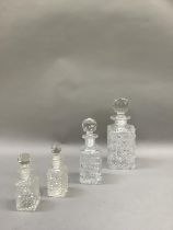 An early 20th century square glass decanter of hobnail cut with globular facetted spherical stopper,
