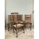 A set of four wavy ladderback, rush seated dining chairs, carver and three singles