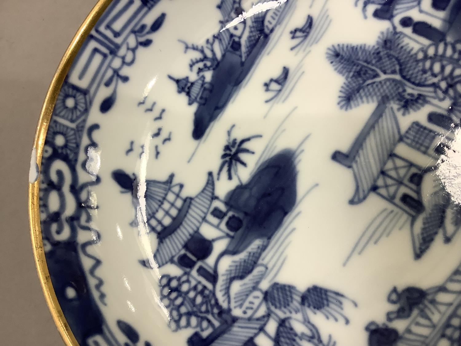 A Chinese export blue and white cup and saucer painted with the willow pattern with gilt - Image 6 of 9