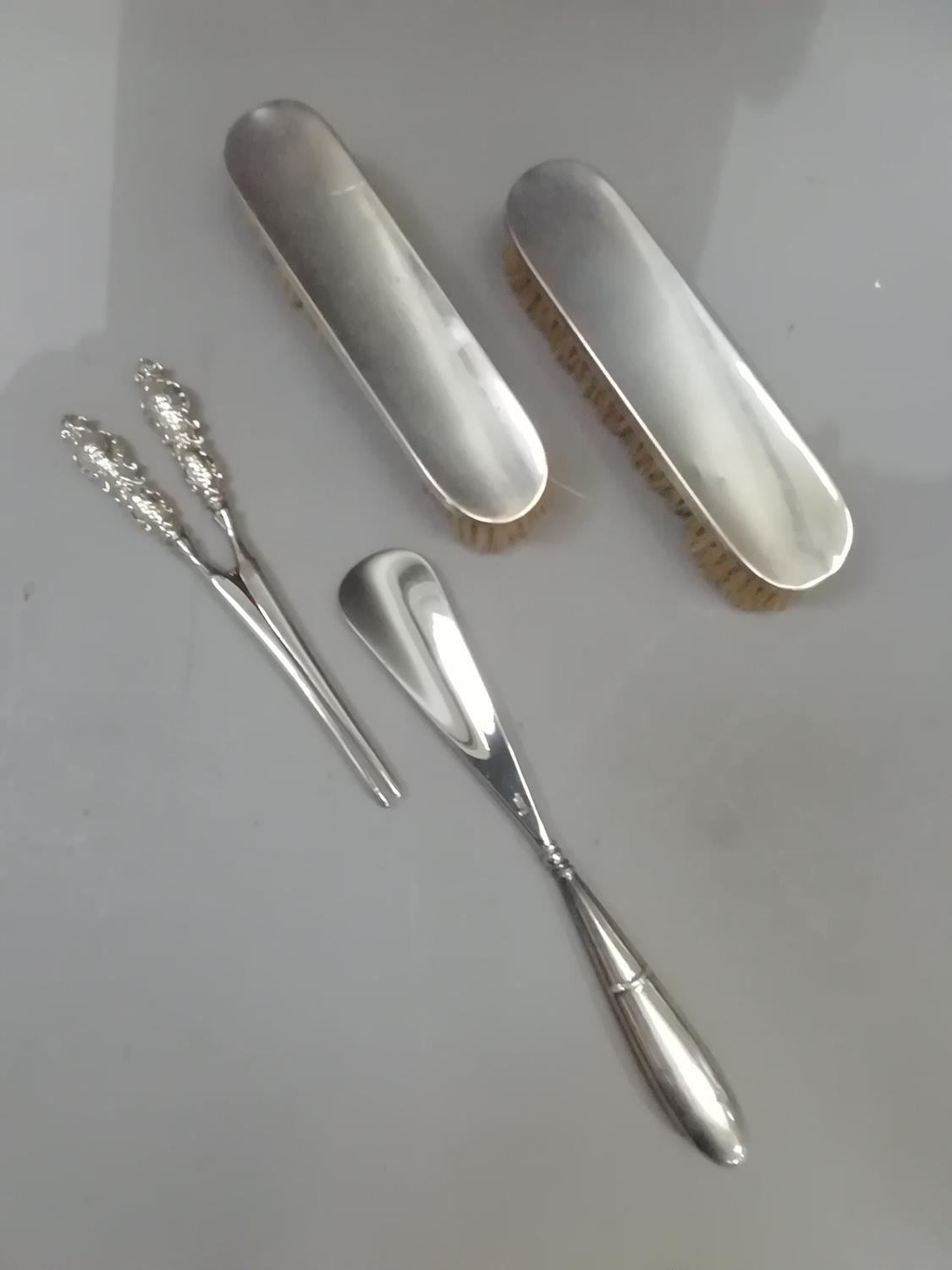 A pair of silver hairbrushes, Sheffield 1904/15, a pair of plated glove stretchers and a shoe horn