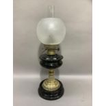 A Victorian black glass and brass oil lamp with opaque etched shade