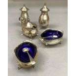 A group of late 19th/early 20th century silver condiments with associated spoons and blue glass