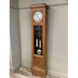 A 1930s oak and glazed longcase clock having a silvered dial with black Arabic numerals above a