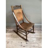 A Victorian polished beech rocking chair with embossed panel for back and seat