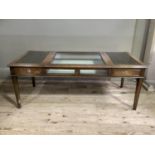 A mahogany centre table having a glazed bijouterie centre flanked by leather incised surface to