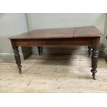 A Victorian mahogany dining table, rectangular with rounded corners, on inverted tulip and turned