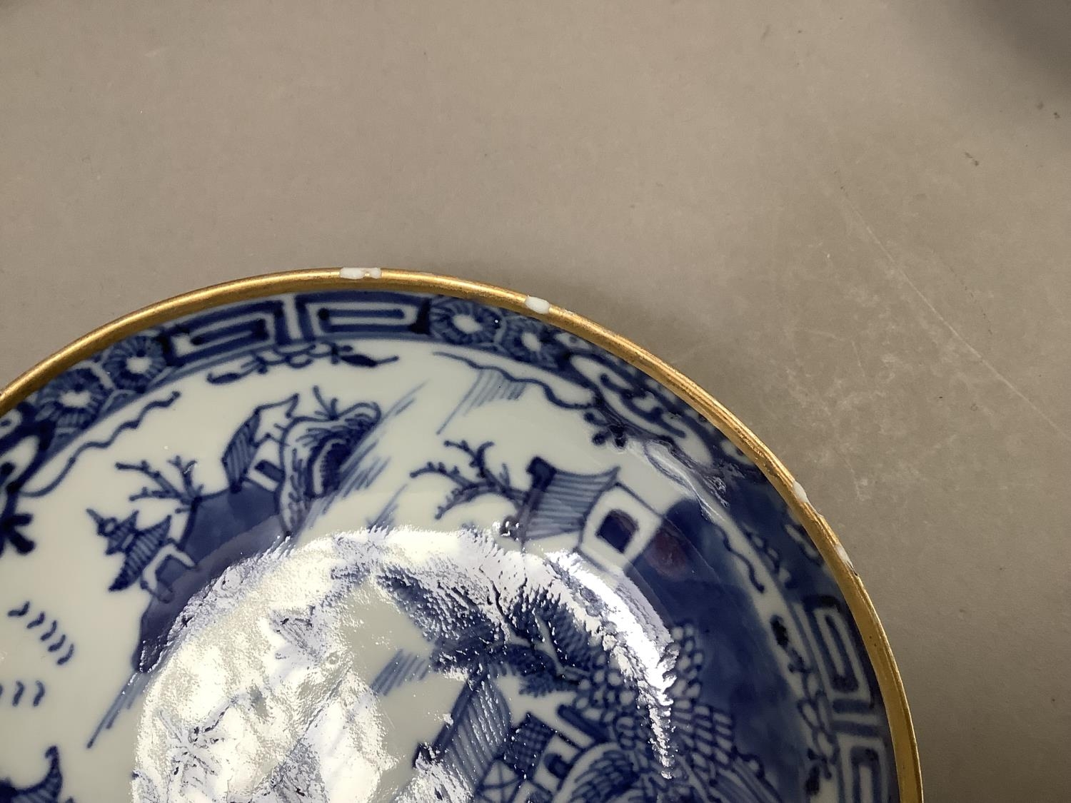 A Chinese export blue and white cup and saucer painted with the willow pattern with gilt - Image 7 of 9