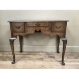 A rectangular oak side table having three small drawers to the double ogee arched apron and on