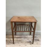 An early 1970s teak occasional table, rectangular with railed undertier and on slender tapered legs,