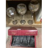 A boxed set of six wine glasses and three ornamental outsize wine goblets with silver and gilt