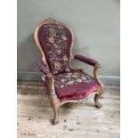 A Victorian bleached walnut armchair having an encircling frame with foliate cresting, floral