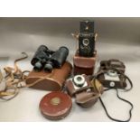 A leather cased cloth tape, 66 foot long, a pair of Prince 7x50 field glasses, a Voigtlander