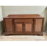 A modern cherry wood finish sideboard having a drawer to the centre above two door cupboard