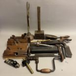 A collection of wood working tools including moulding planes, hand drill, shavespoke stamped with