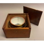 A lacquered brass gimbal mounted compass in oak case with sliding top (no compass dial)