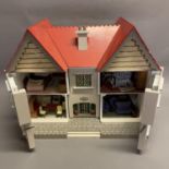 A doll's house, double gable front with lattice windows, the facade opening in three sections, fully
