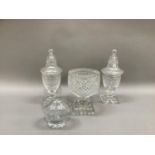 A pair of cut glass bonbonnieres, the covers bell shaped with knopped finial on a panelled