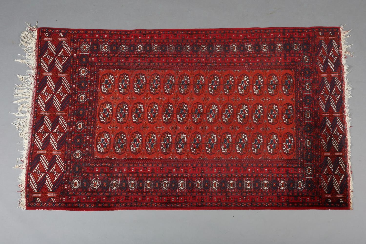 A BOKHARA RUG OF FOX RED GROUND filled with three rows of thirteen 'elephant foot' medallions within