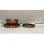 A vintage copper sieve, a copper and cast iron handled skillet and a two handled copper lid of