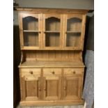 A pine dresser having three glazed doors above three drawers and three door cupboard below, 137cm